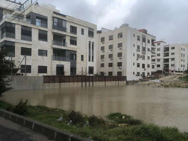 بركة مياه تهدد عمارة سكنية في خلدا  صور
