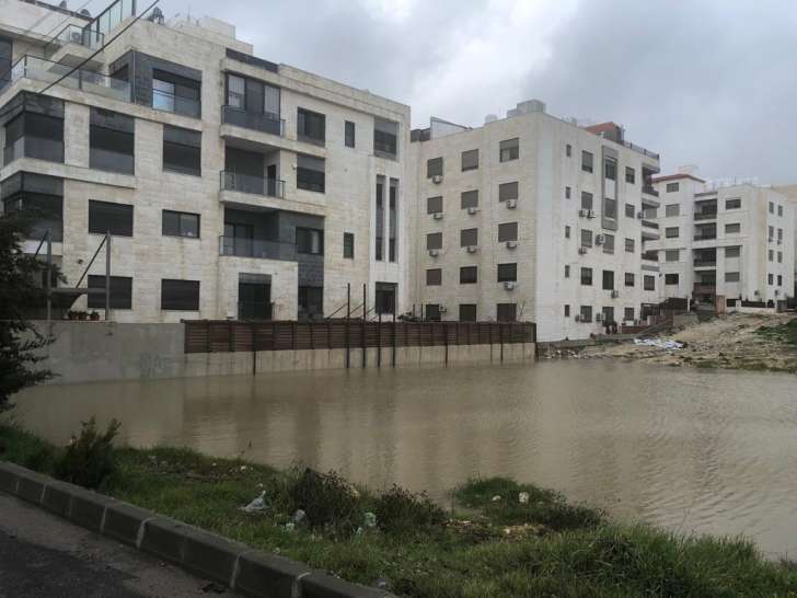 بركة مياه تهدد عمارة سكنية في خلدا - صور