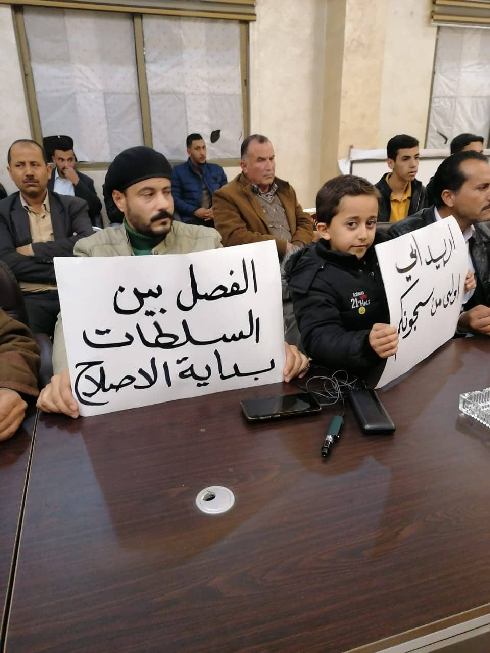 ناشطون من حراك بني حسن يرفعون لافتات في وجه الوزير المعايطة تطالب بالافراج عن المعتقلين - صور